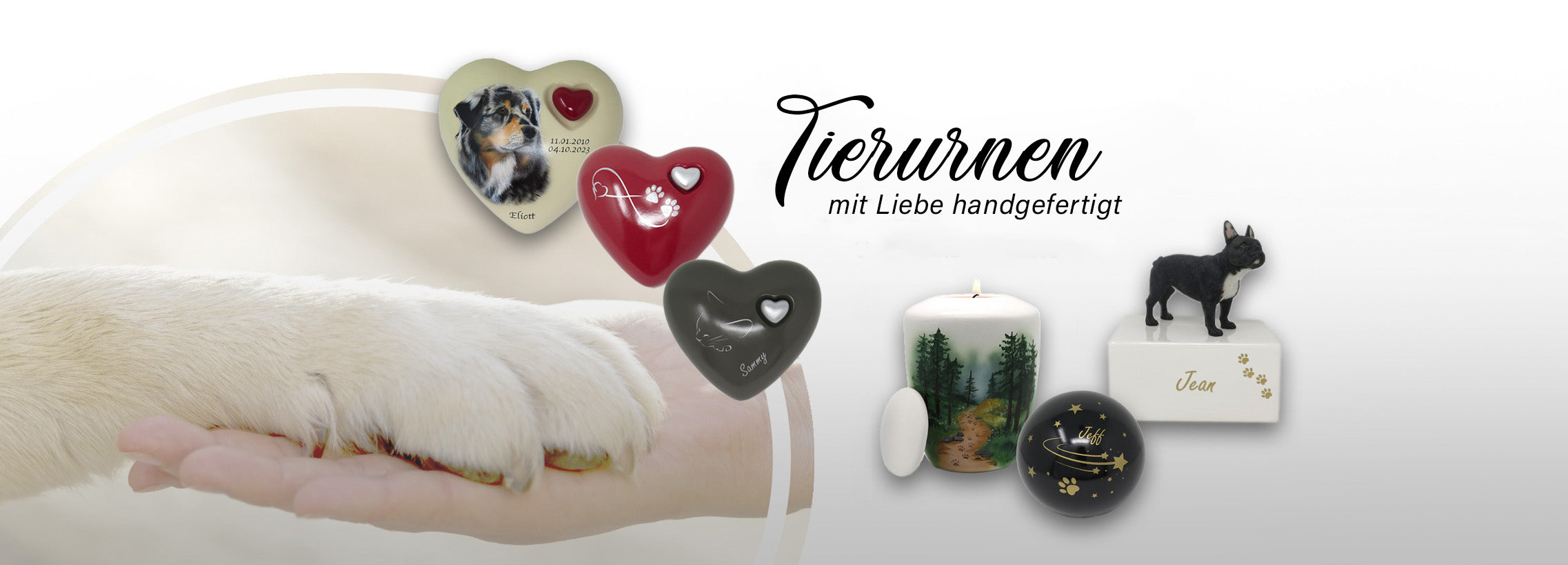 Das Bild enthält eine Hand auf der sanft eine beige Hundepfote liegt. Das ist der Hintergrund. im vordergrund sind drei Herzförmige Urnen zu sehen. Eine Beige mit einem Hundeportrait, eine Rote mit einem silbernen Unendlichkeitssymbol mit Pfote integriert und eine graue mit einer silhouette einer Katze. Rechts daneben sind drei weitere urnen zu sehen. Eine Kugelförmige schwarze mit goldenen Sternen, eine weiße Vasenförmige mit deckel und Teelicht  und eine mit einer Hundefigur. Darüber der Text "Tierurnen"