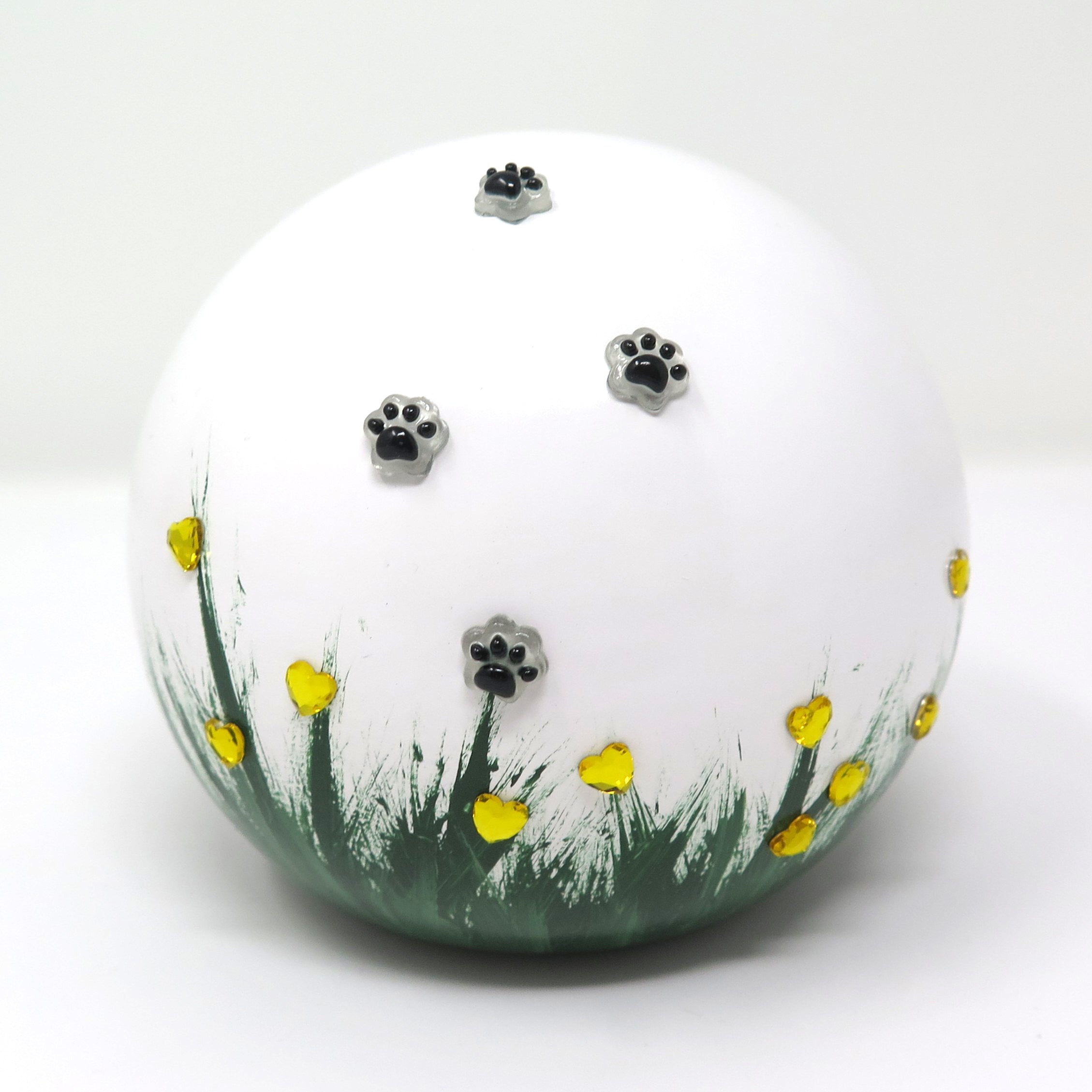 weiße tierurne in kugelform mit 3d applikationen die im dunkeln leuchten