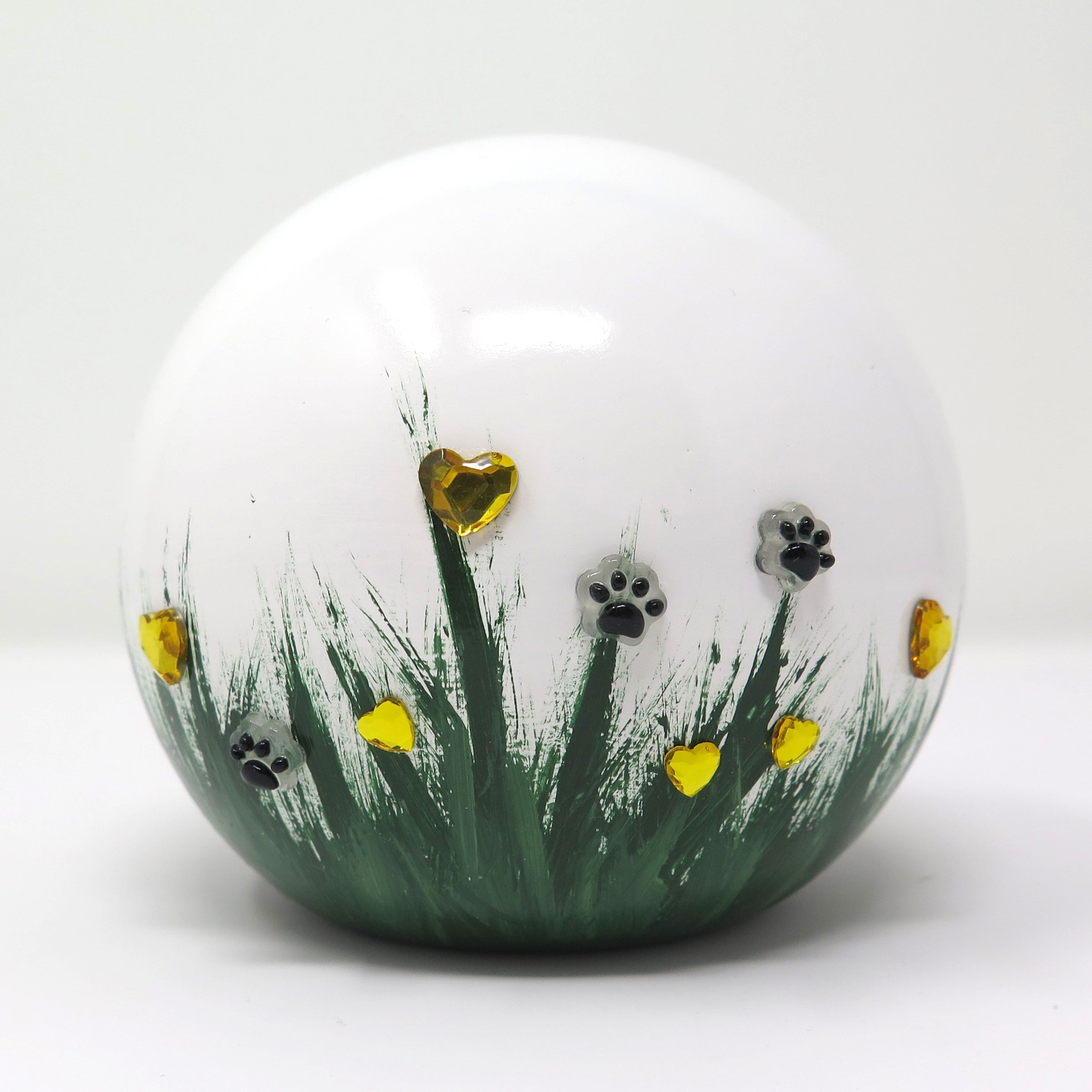 weiße tierurne in kugelform mit 3d applikationen die im dunkeln leuchten