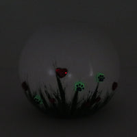 weiße tierurne in kugelform mit 3d applikationen die im dunkeln leuchten