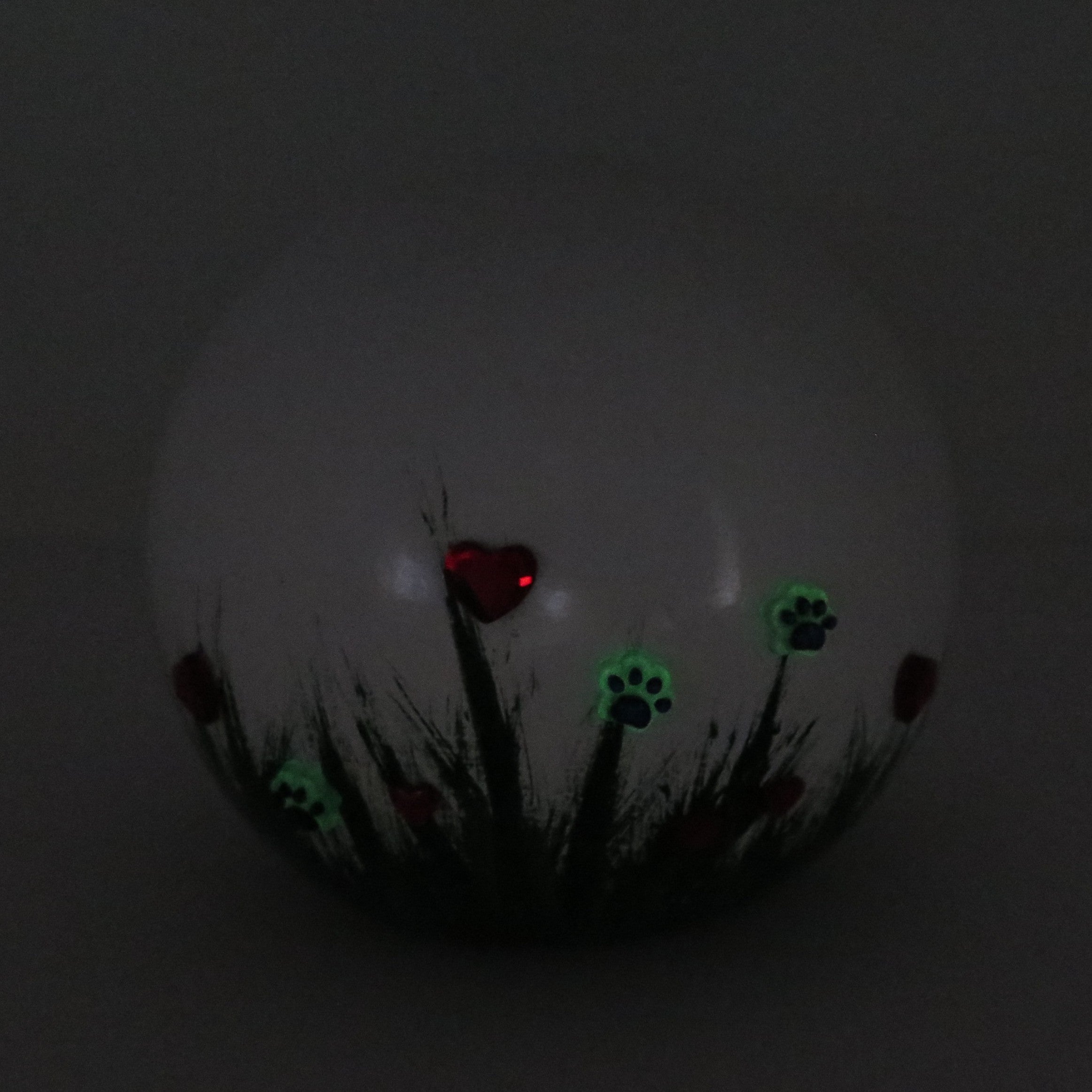 weiße tierurne in kugelform mit 3d applikationen die im dunkeln leuchten