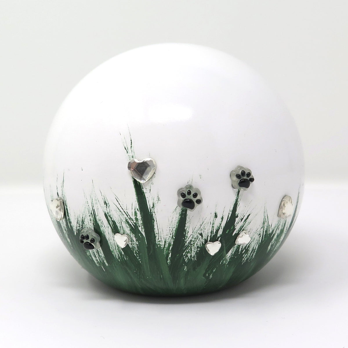 weiße tierurne in kugelform mit 3d applikationen die im dunkeln leuchten