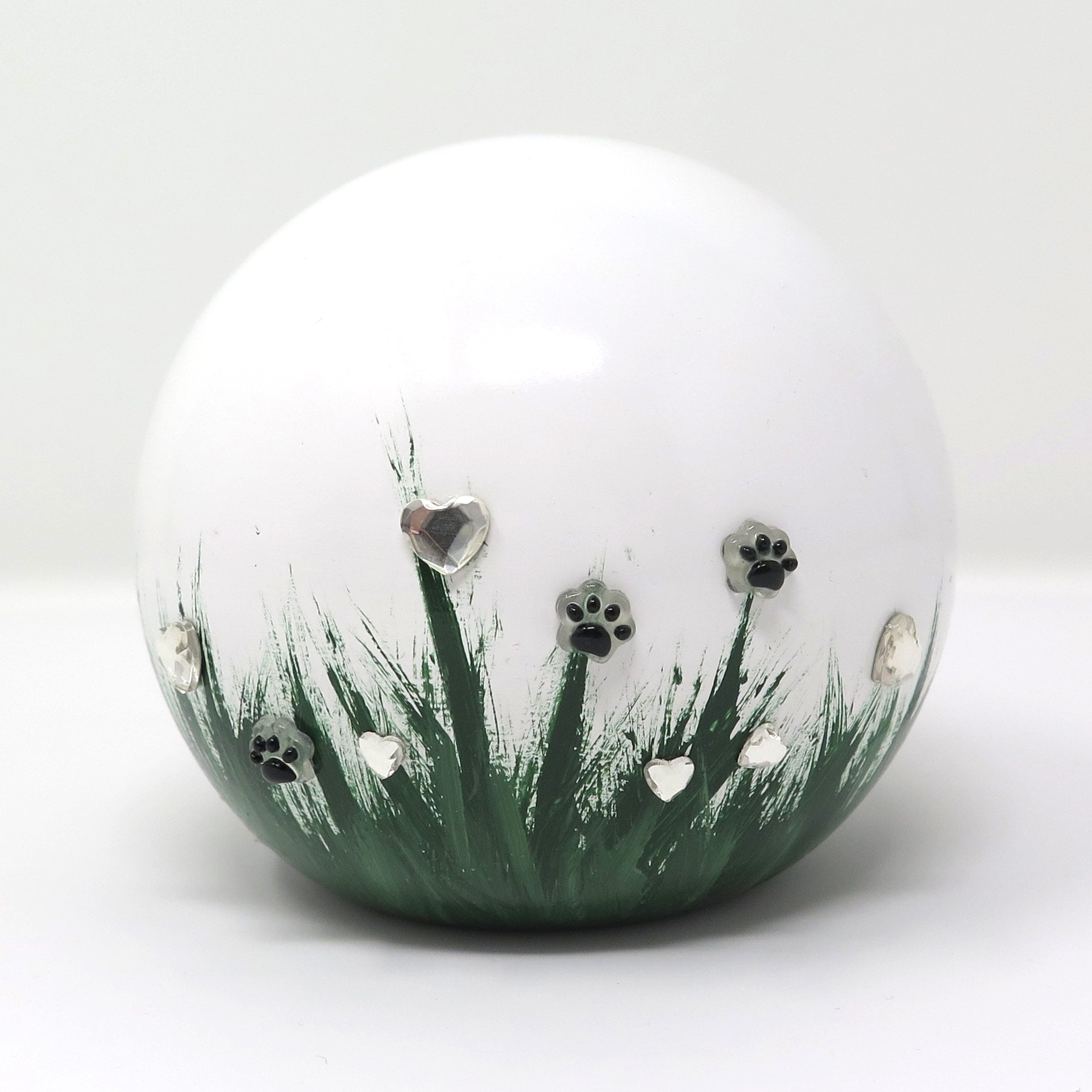 weiße tierurne in kugelform mit 3d applikationen die im dunkeln leuchten