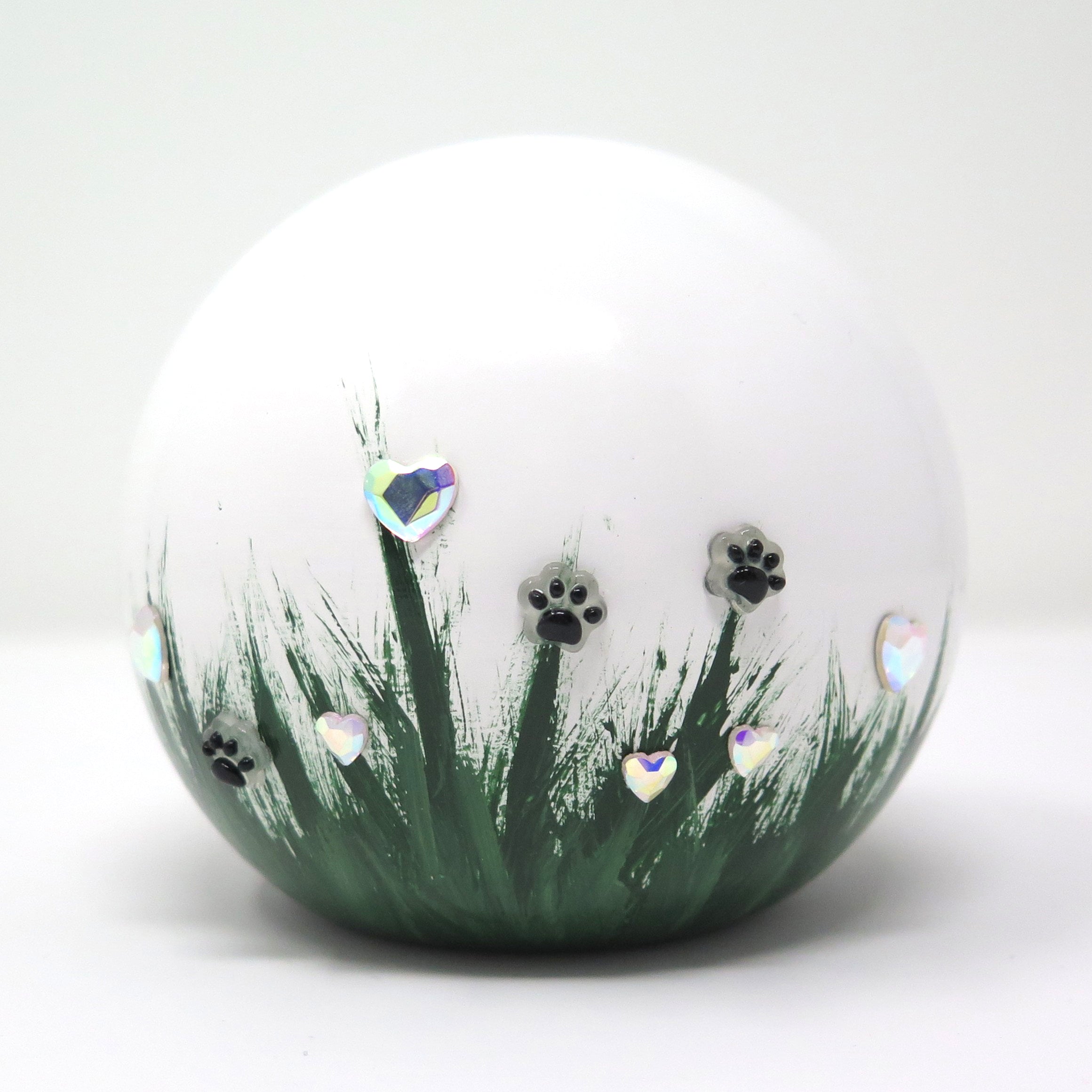 weiße tierurne in kugelform mit 3d applikationen die im dunkeln leuchten