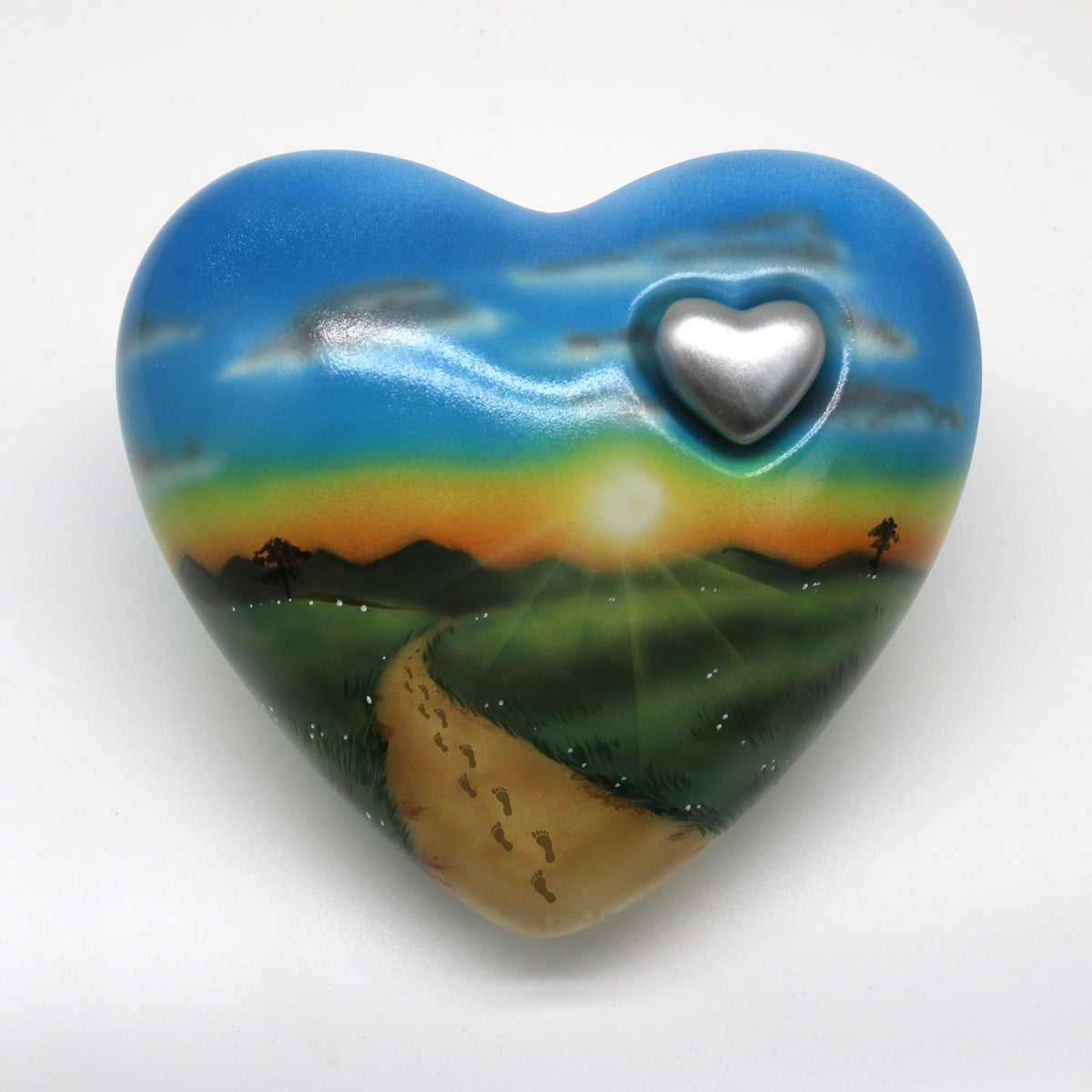 Tierurne in Herzform mit einer Sonnenuntergangslandschaft bemalt