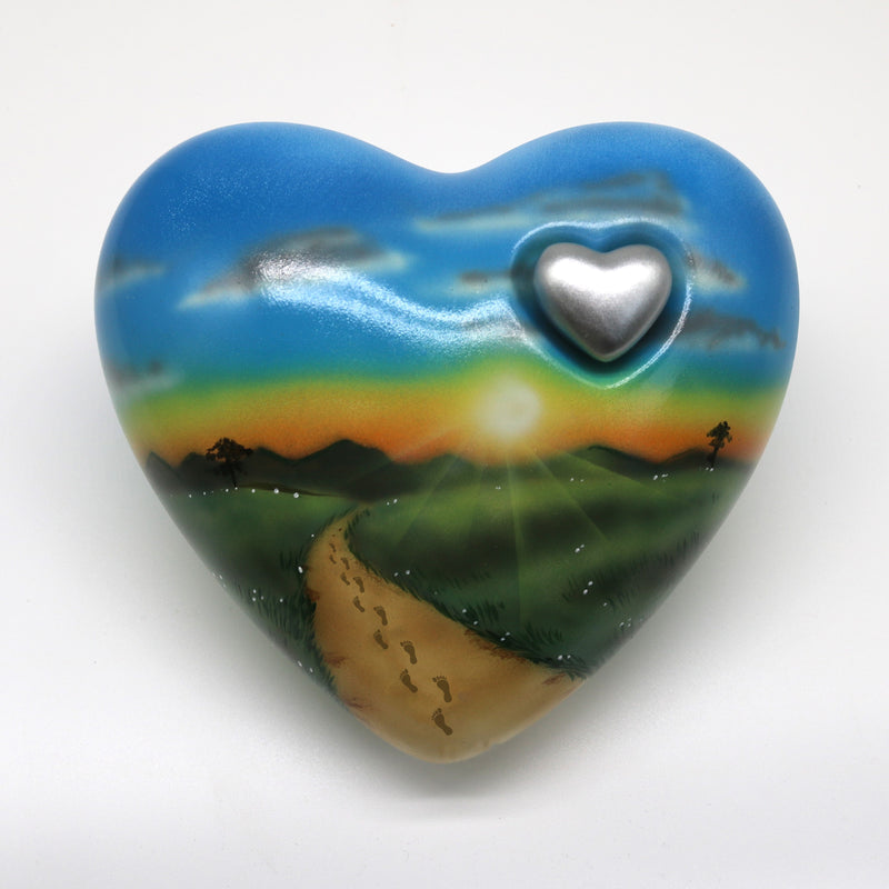 Tierurne in Herzform mit einer Sonnenuntergangslandschaft bemalt
