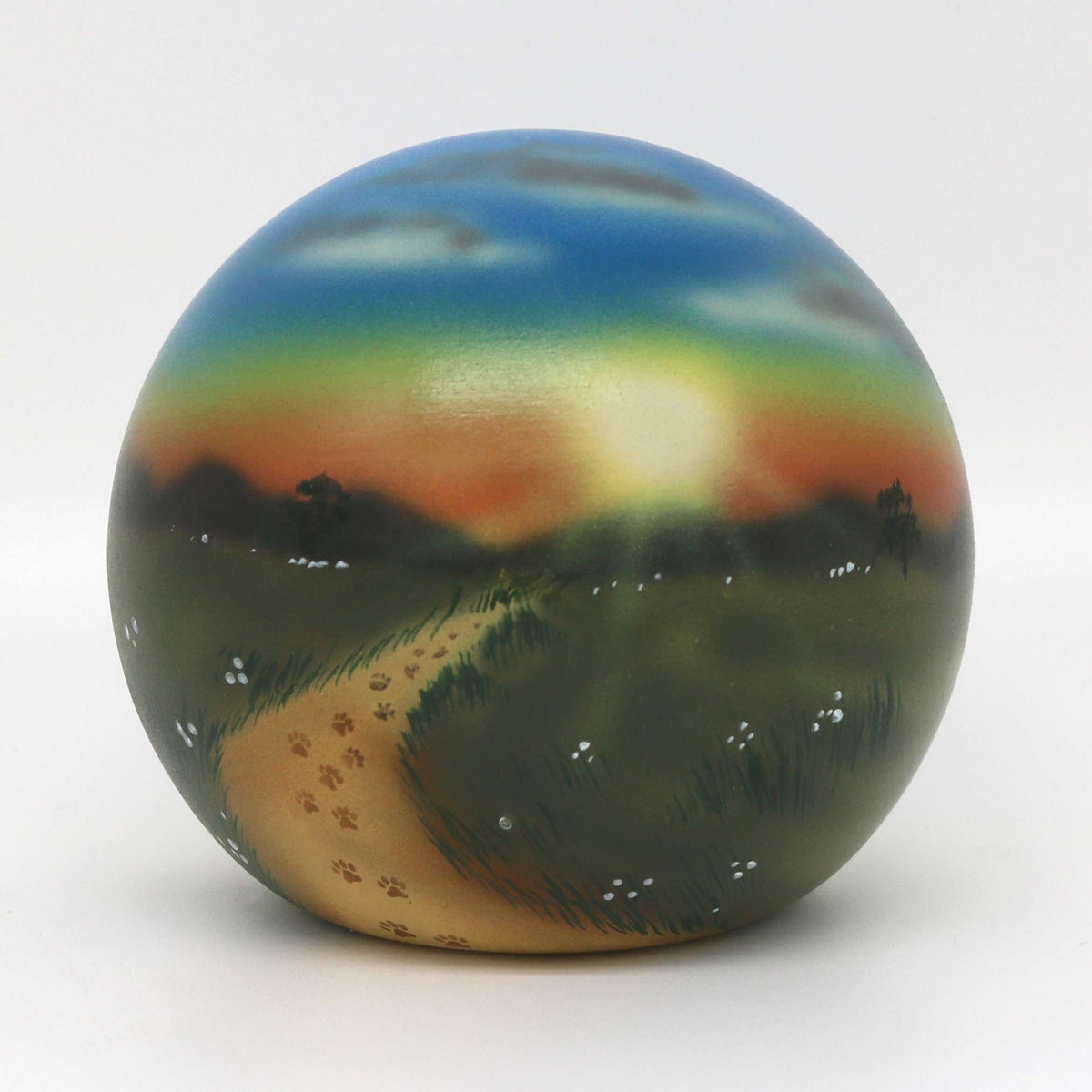 Tierurne in Kugelform mit Blumenwiese im Sonnenuntergang 