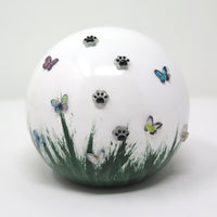 weiße tierurne in kugelform mit 3d applikationen die im dunkeln leuchten