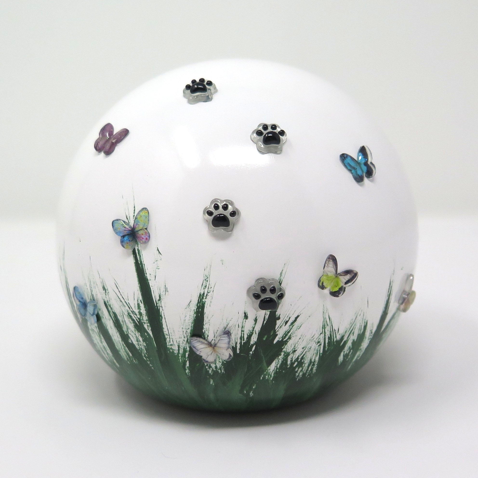 weiße tierurne in kugelform mit 3d applikationen die im dunkeln leuchten