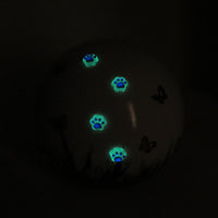 weiße tierurne in kugelform mit 3d applikationen die im dunkeln leuchten