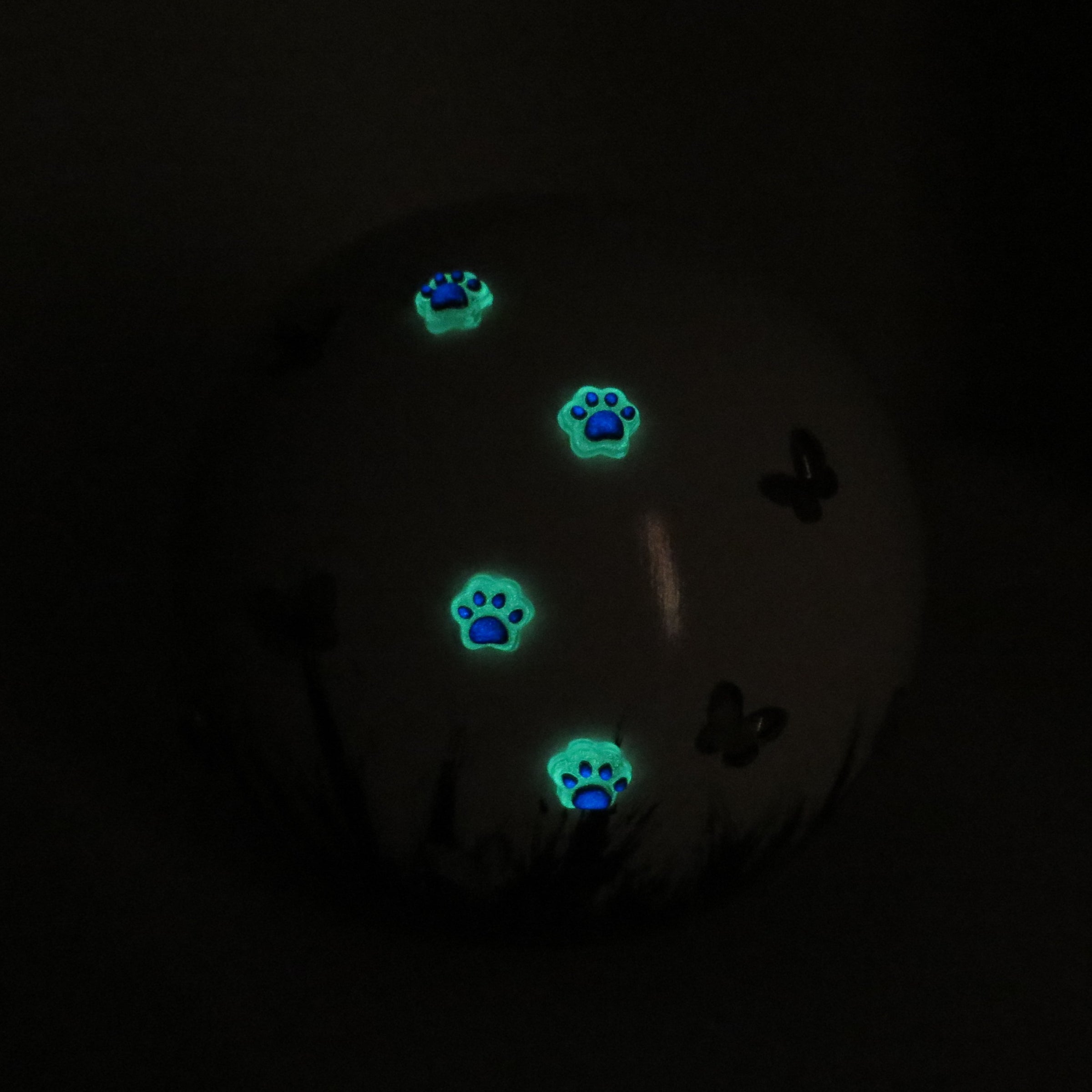 weiße tierurne in kugelform mit 3d applikationen die im dunkeln leuchten