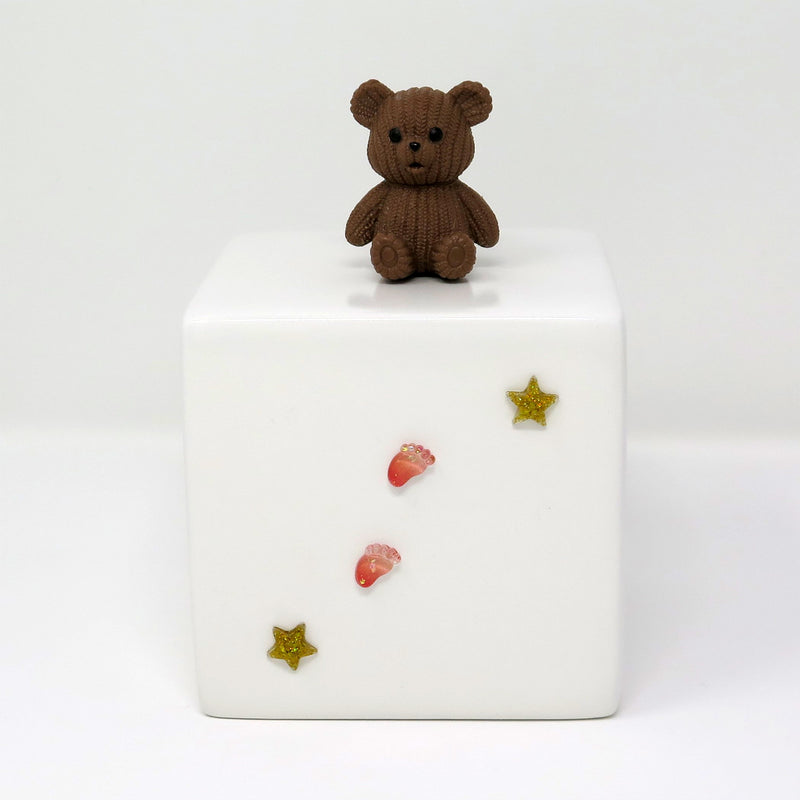 Kinderurne in Würfelform mit dunkelbraunem Teddybär