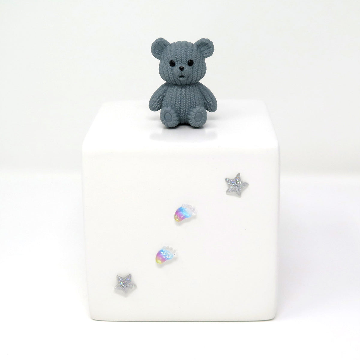 Kinderurne in Würfelform mit grauen Teddybär
