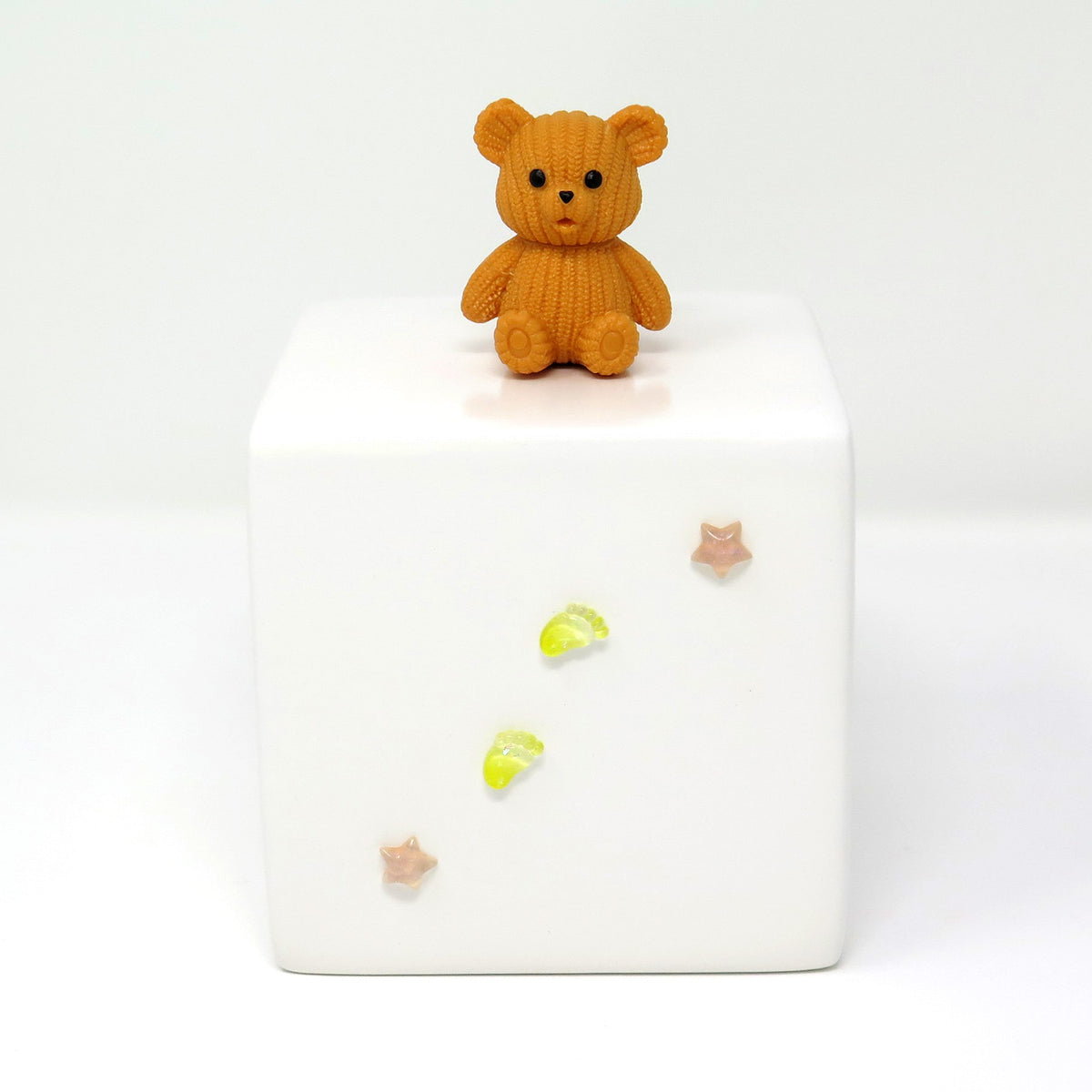 Kinderurne in Würfelform mit hellbraunem Teddybär