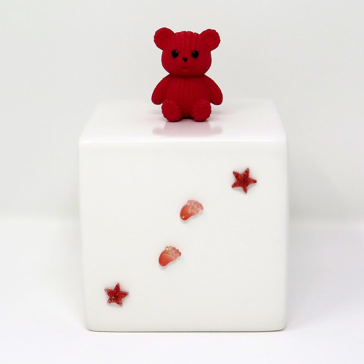Kinderurne in Würfelform mit rotem Teddybär