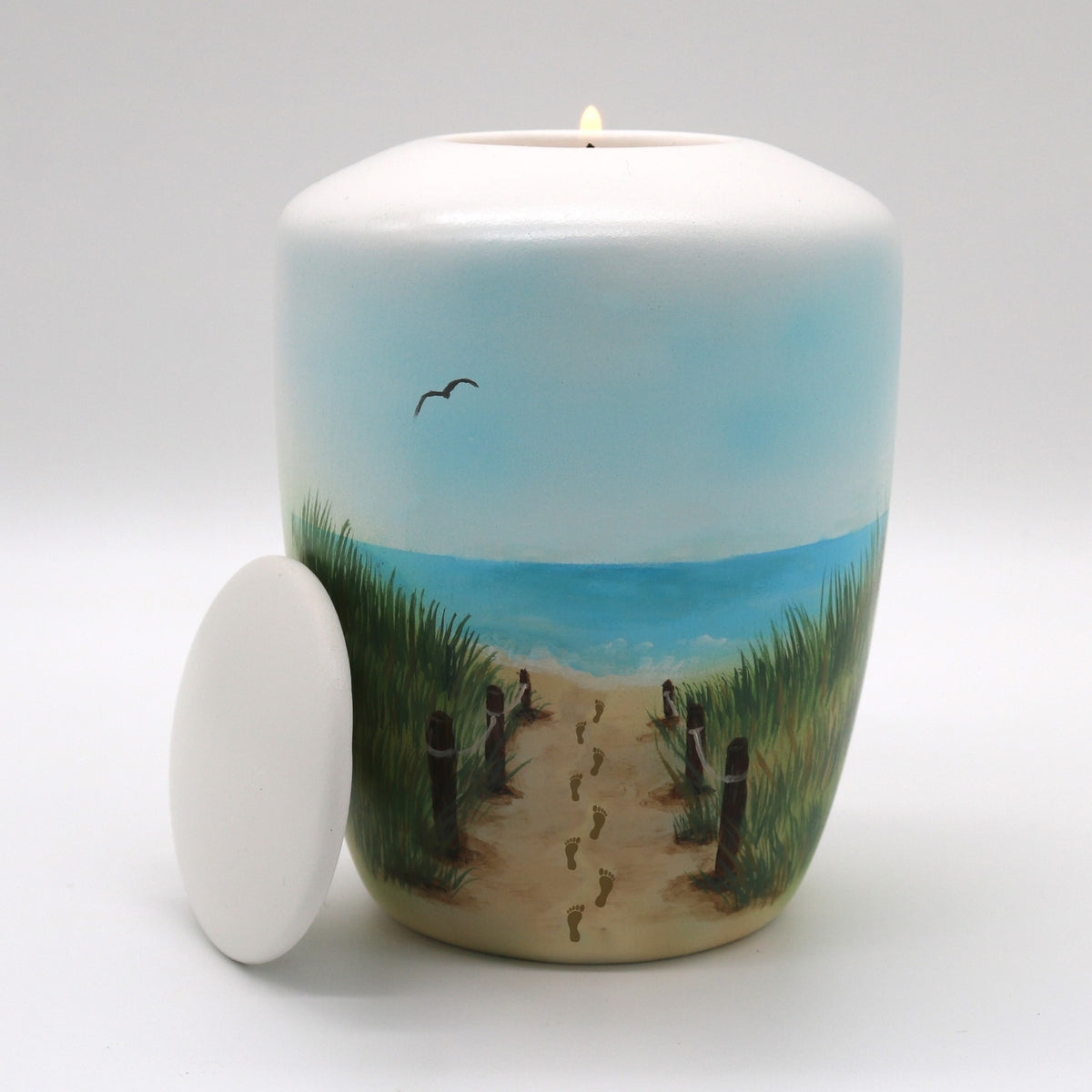 Tierurne mit Teelichteinsatz mit einer Dünenlandschaft bemalt.